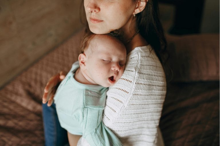 Parent gently holding and soothing their baby